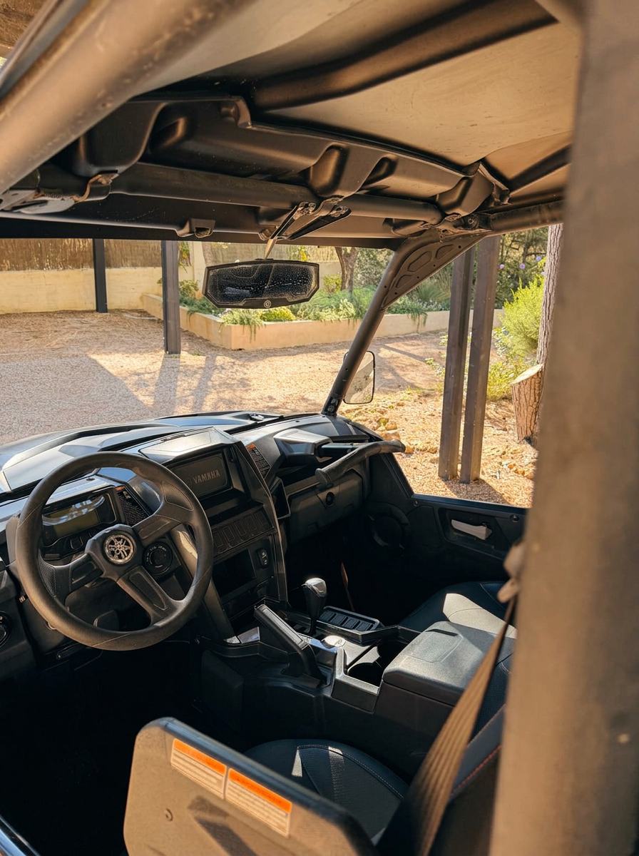 Driver's view inside the Yamaha Wolverine buggy with steering wheel, dashboard and Can Serenico garden beyond