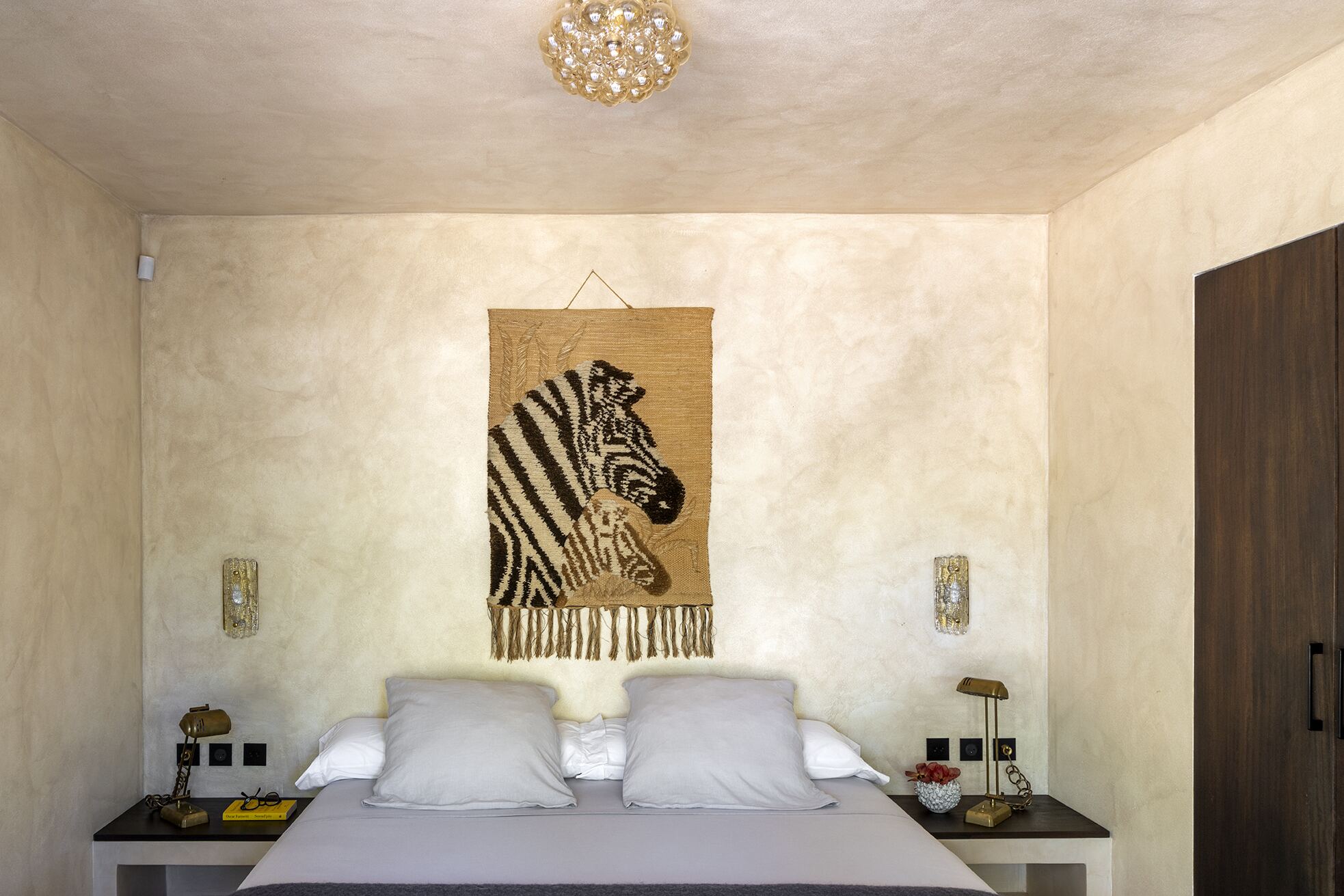 Guest bedroom with woven zebra tapestry above the bed