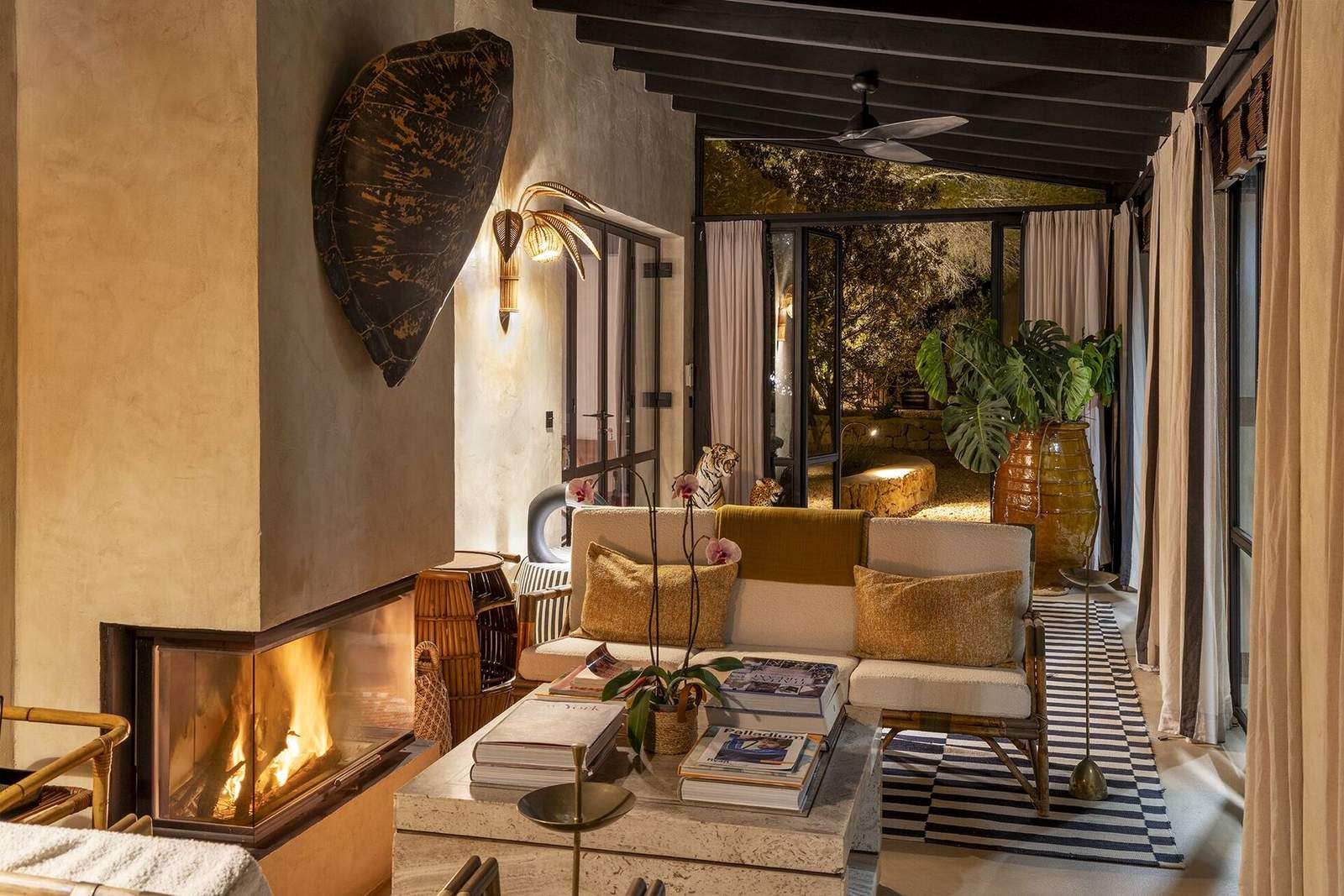 Guest house sitting room with fireplace and bouclé sofas at dusk