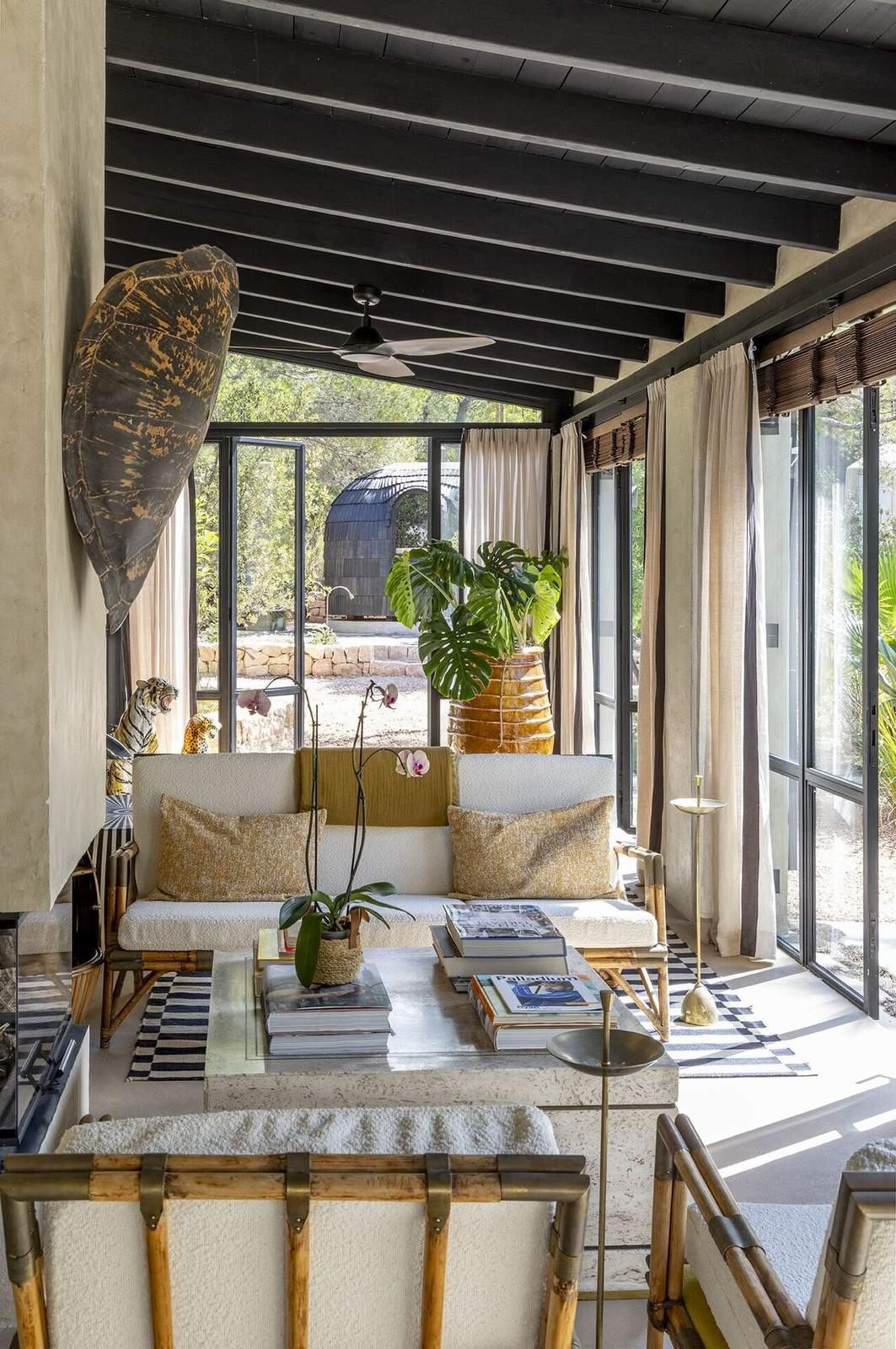 Bouclé sofa in the sunroom framed by orchids and a view to the garden dome