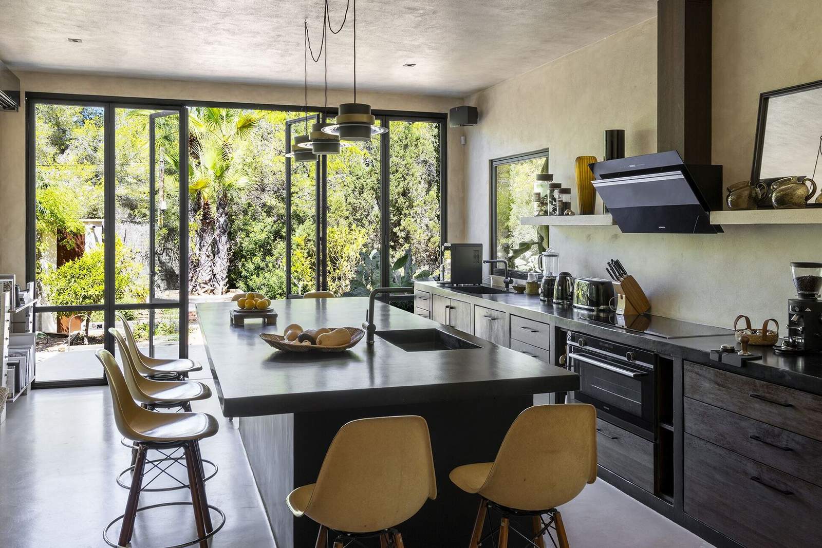 Large kitchen island with bar stools and garden view