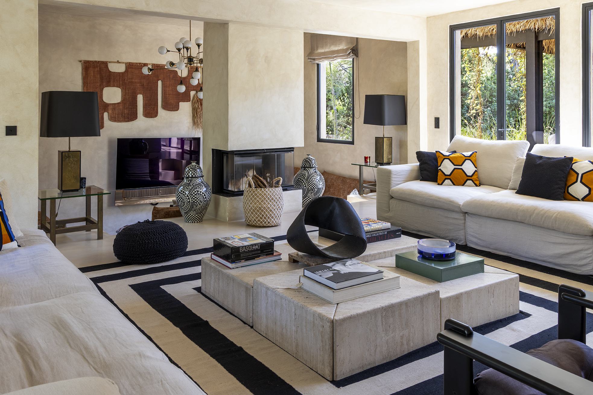 The main house living room fireplace at Can Serenico with the television wall beside it, sofas drawn close to the hearth for a winter evening