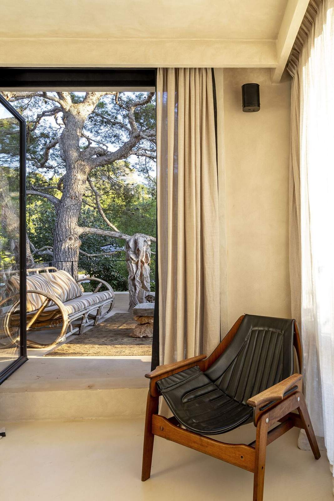 Master bedroom with leather sling chair and pine view