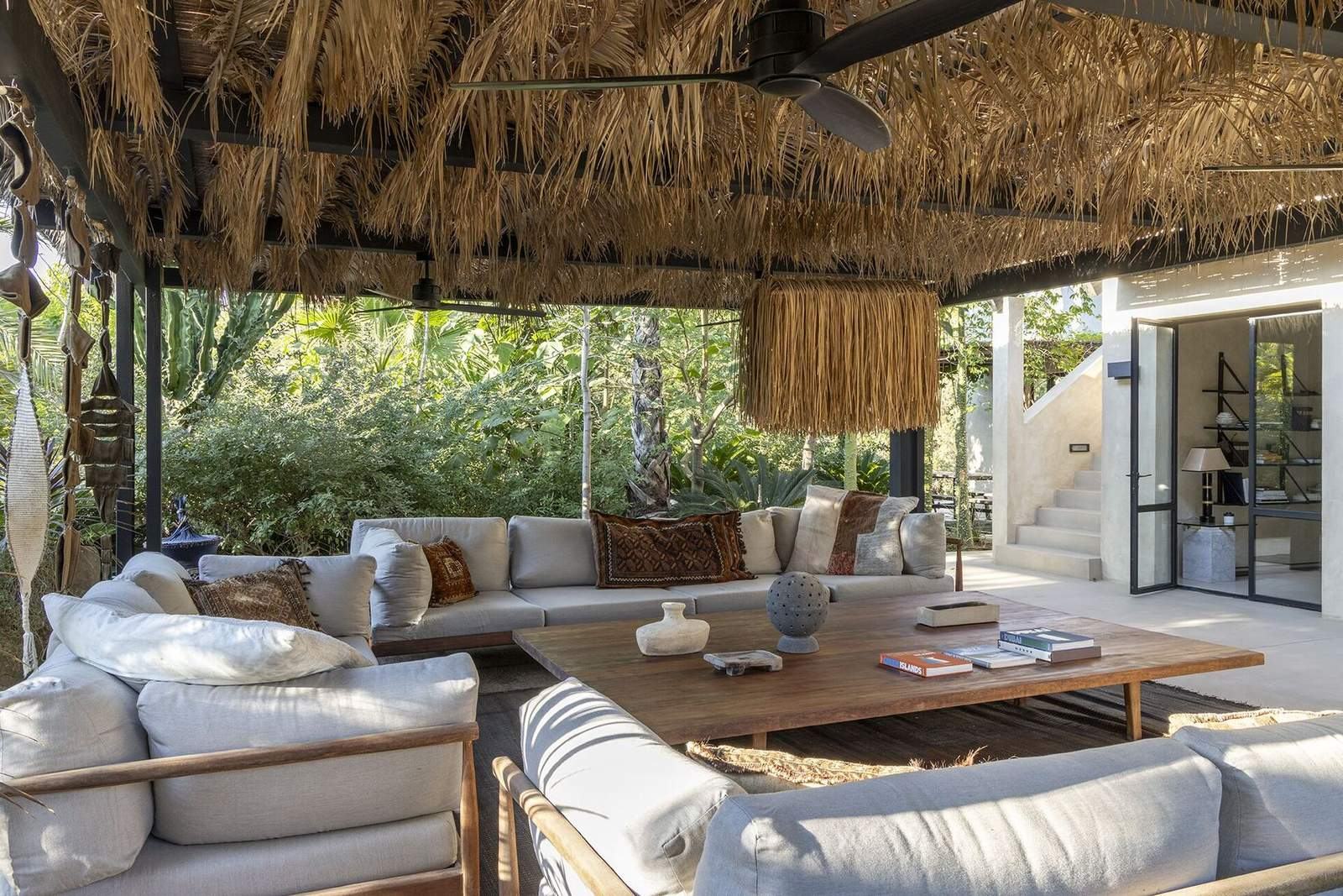 Pergola seating area connecting through steel-framed doors to the indoor living room and stair