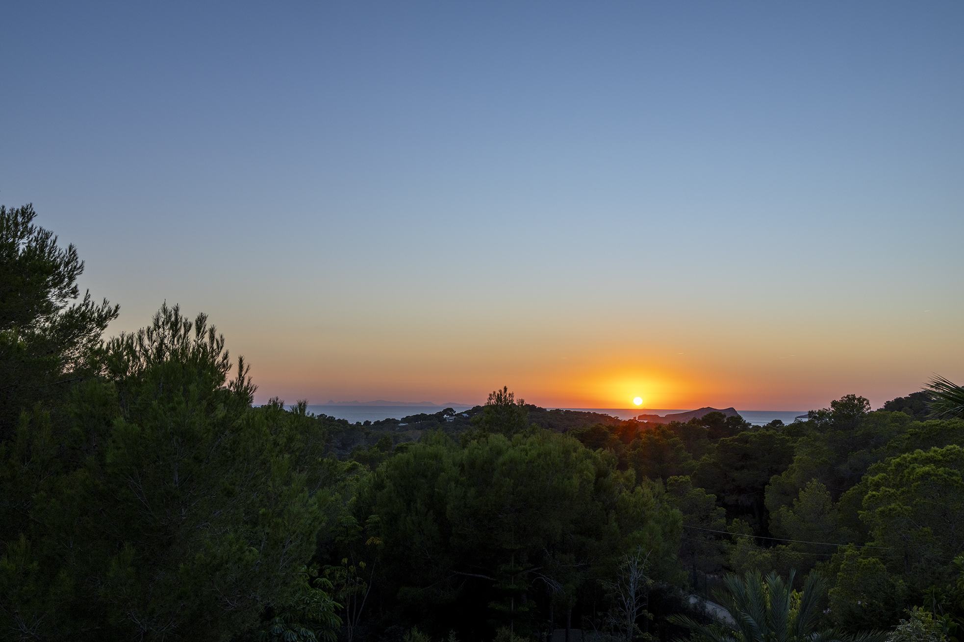 Sunset over the sea seen from the garden at Can Serenico